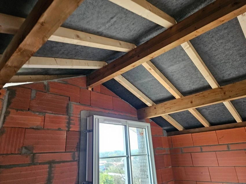 Intérieur d'une structure en bois avec charpente apparente et plafond voûté
