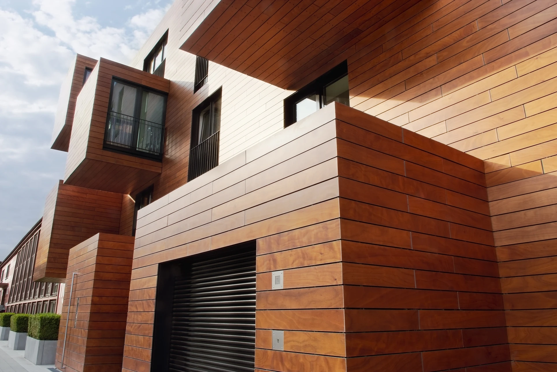 Façade extérieure d'immeuble résidentiel moderne avec bardage bois horizontal en lames de cèdre ou essence similaire