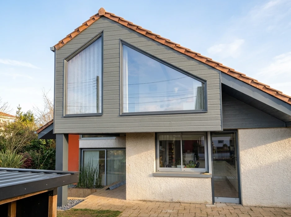 Maison individuelle contemporaine vue de l'extérieur, façade enduit blanc et bardage composite gris anthracite